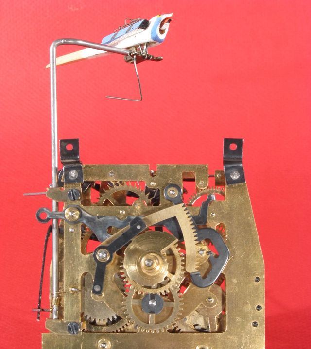 A time-and-strike movement with a wire up to a cuckoo instead of a hammer
