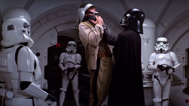 Darth Vader choking a rebel soldier as storm troopers watch
