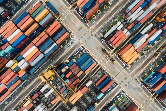 A shipping yard from above, with rows of colorful stacked shipping containers

