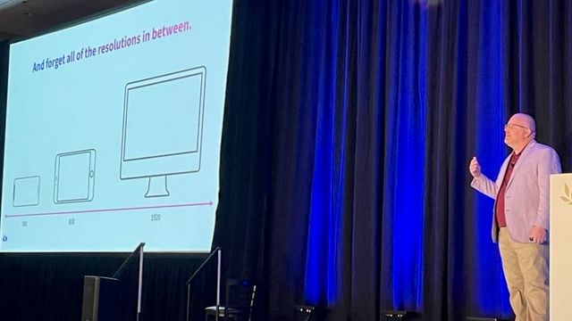 Jason Grigsby on stage at AEA Denver,
with a slide that shows outlines
of a phone, tablet, and desktop
with the headline
'And forget all of the resolutions in between'
