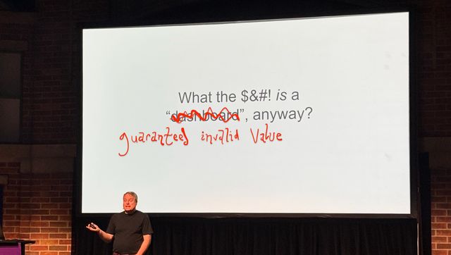 Nick Desbarats on stage in front of a slide that said What the $&#! is a dashboard anyway - but dashboard has been scribbled out and replaced with hand-written guaranteed invalid value
